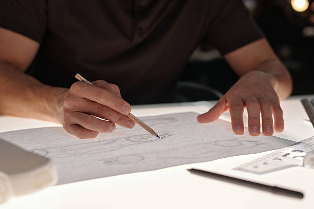istock Man drawing sketches of new car models 2207685048