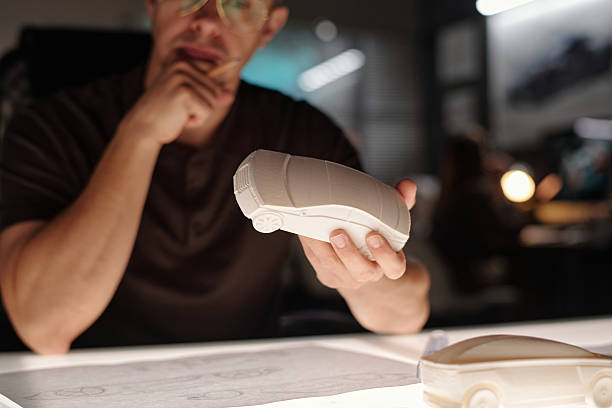 Male designer holding white car model