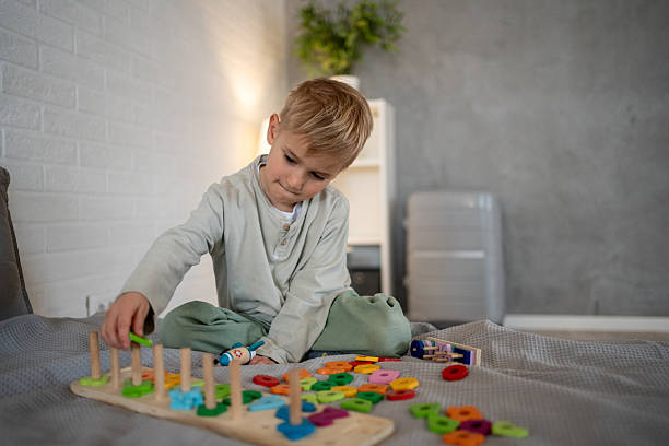 istock Little boy playing with colorful educational toys on bed 2207685435