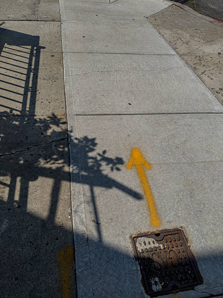 istock A spray-painted yellow arrow  on the sidewalk 2207690141