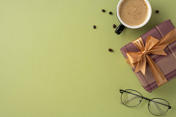istock A stylish scene featuring a coffee cup, gift box, and glasses on a green backdrop 2207690376