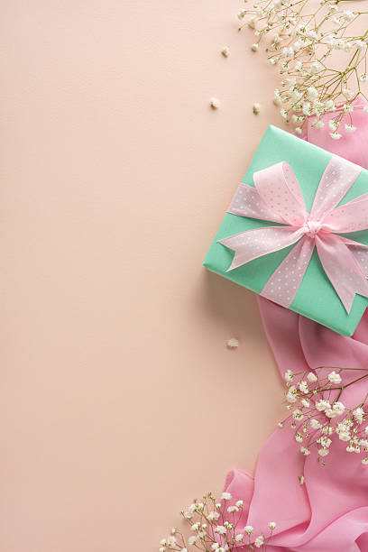 istock Delicate vertical pastel composition featuring a gift box, pink ribbon, sheer fabric, and baby's breath flowers symbolizing celebrations, greetings, or special occasions with softness and femininity 2207690381