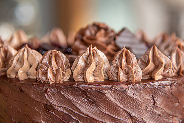 istock Beautifully decorated chocolate cake decorated with layers for birthday, wedding with blurred house background 2207690771