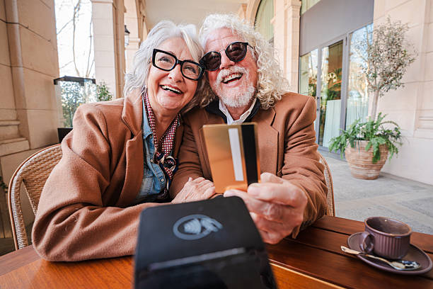 istock Joyful elderly couple happily taking a selfie while enjoying their time together at a cafe with their credit card in hand, celebrating love and companionship during a delightful afternoon outing 2207697797