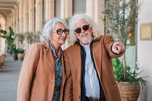 istock Joyful elderly couple enjoying a delightful day outdoors while pointing excitedly at an interesting sight together during their leisurely stroll along the charming promenade filled with lively energy 2207697982