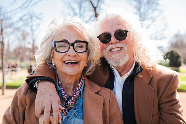 Portrait Of Loving Senior Couple Sitting On Sofa At Home Together
