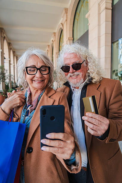 istock Joyful senior couple happily taking a selfie while shopping together, showcasing their excitement and connection through their smartphone and credit card in a delightful moment of togetherness 2207699305