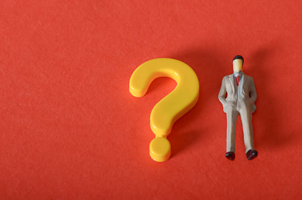 Career Choices Concept: Businessman Figurine Facing a Question Mark Symbol
