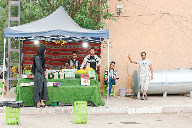 Tamanrasset, Algeria- March 25, 2025: The vendors and friends smile, pose for the camera, and make friendly hand signs.