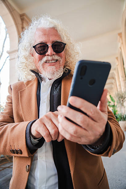 istock Elderly man enjoying a moment of connection while using his smartphone to engage with friends and family through social media or messaging applications he accesses on the device in his hands 2207700419