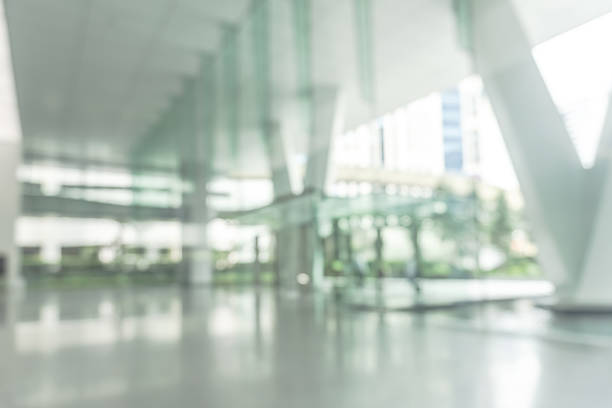 istock Blurred business office building lobby or hotel blur background interior view toward reception hall, modern luxury lounge, white room space with blurry corridor and glass wall 2207701815