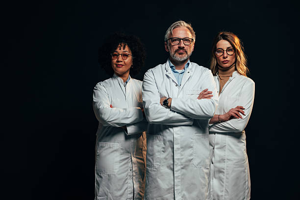 istock Confident medical team posing with arms crossed on black background 2207702966