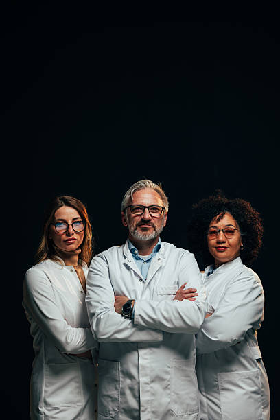 istock Confident medical team posing with arms crossed on black background 2207702991