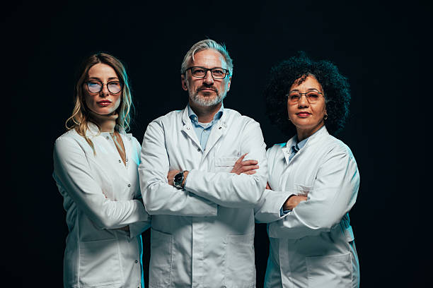 istock Confident medical team posing with arms crossed on black background 2207702992