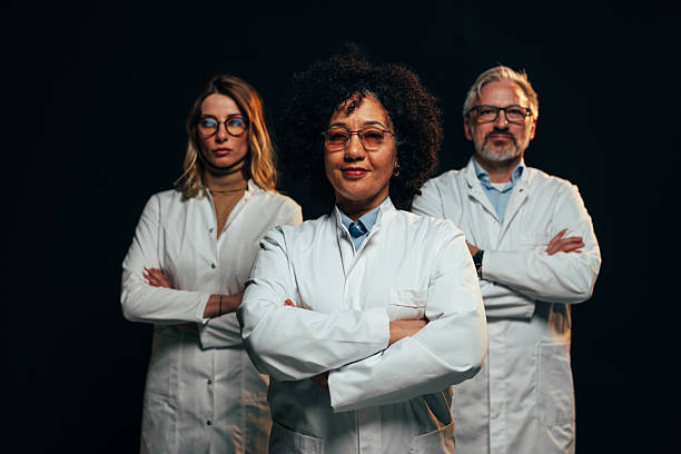 istock Confident scientists posing with arms crossed on black background 2207702994