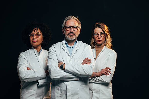 istock Confident medical team posing with arms crossed on black background 2207702999