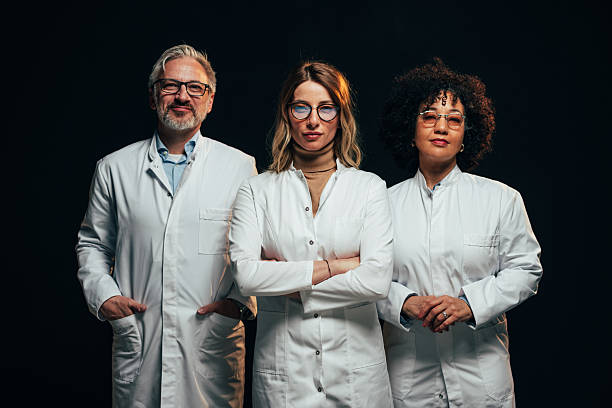 Confident medical team posing with arms crossed on black background