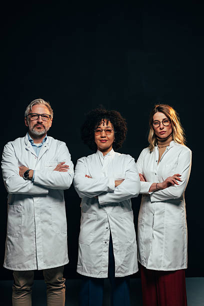 istock Confident medical team posing with arms crossed on black background 2207703014