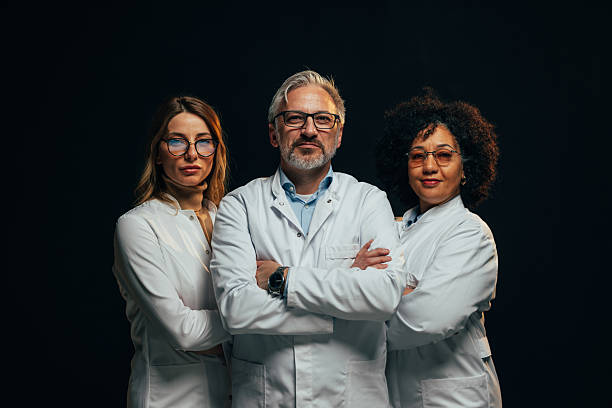istock Confident medical team posing with arms crossed on black background 2207703016