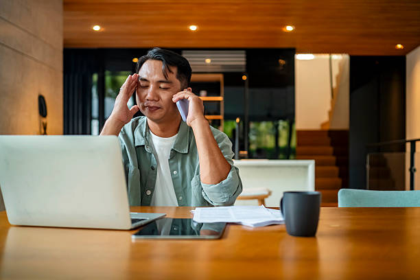 istock Stressed Man on Phone Call at Home Office 2207703601