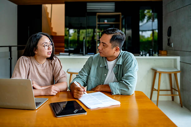 istock Couple Engaged in Serious Conversation at Home Kitchen Table 2207703604