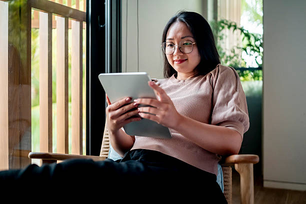 istock Young Woman Relaxing at Home Using a Digital Tablet 2207703617