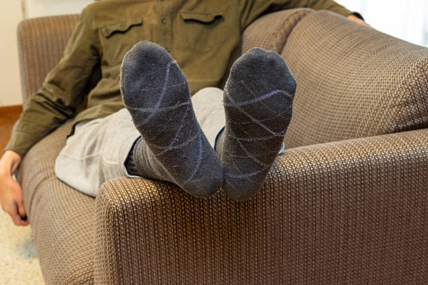 istock Man sitting on sofa with legs crossed 2207706210