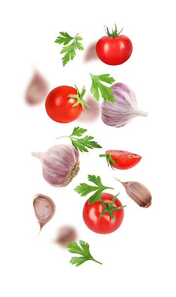 istock Fresh garlic, tomato and parsley falling on white background 2207707344