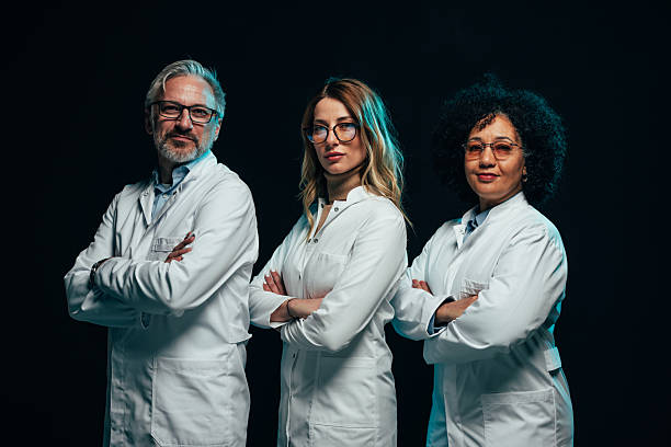 istock Confident medical team posing with arms crossed on black background 2207709797