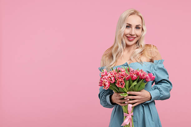 istock Happy young woman with beautiful bouquet on dusty pink background. Space for text 2207711095