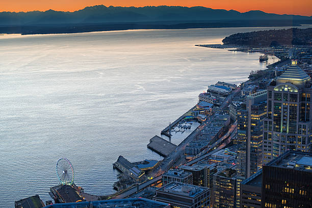 A beautiful night shot of downtown Seattle, Washington, US. There's also a small light trail of a plane in the night sky.