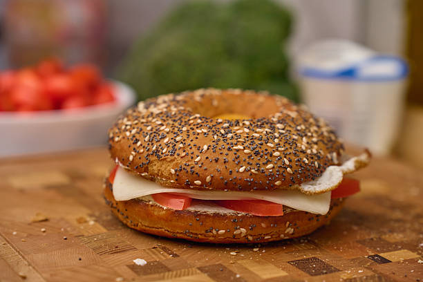 istock Bagel sandwich with fried egg and cheese on wooden board 2207711443