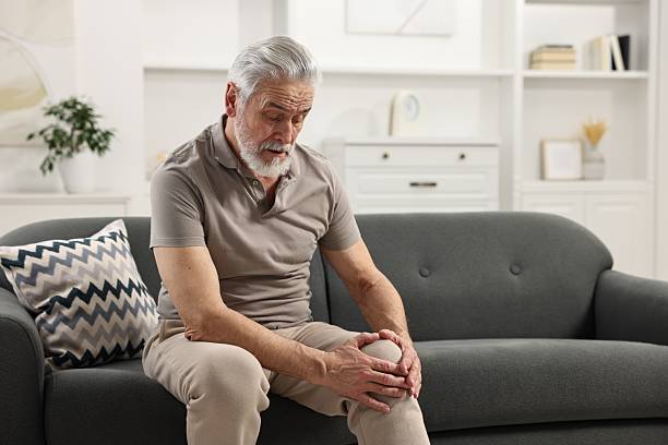 istock Arthritis symptoms. Man suffering from pain in knee at home 2207711721