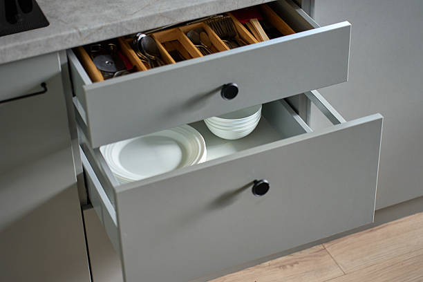 istock Modern kitchen cabinets with dishes and cutlery in open drawers 2207715654