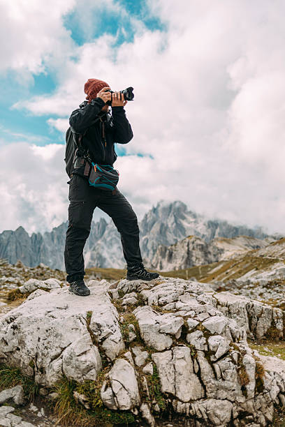 Photographer capturing the beauty of Dolomites under a dramatic sky