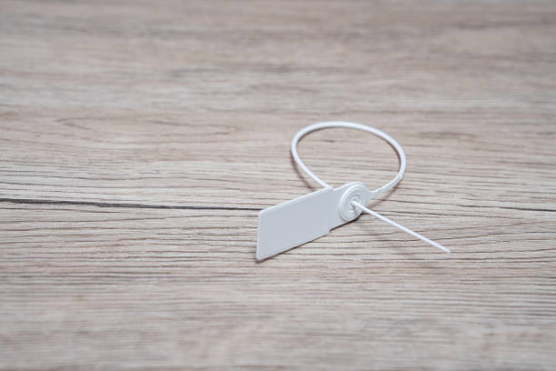 White plastic seal on wooden background. Plastic seal for sealing valuable goods and parcels. Logistics concept.