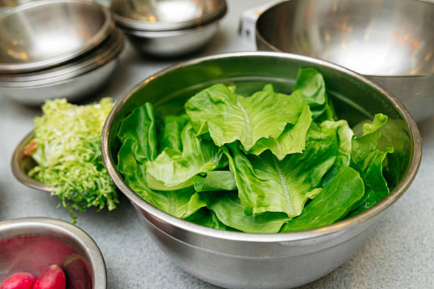 istock Fresh romaine lettuce leaves in metal bowl. 2207719943
