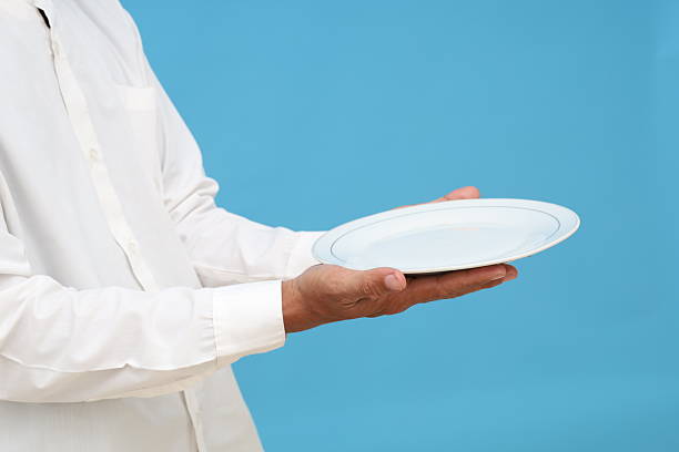 Hand of waiter in suit holding tray with blank card with space for text, service concept