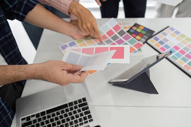 istock Collaboration and Creative Review. Diverse team discussing color palettes and design elements in a modern workspace. 2207721046
