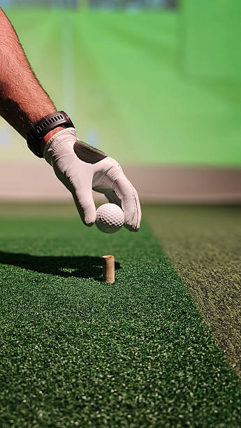 istock Golf ball being teed up for a swing during indoor simulation 2207725495