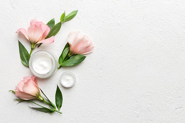 istock Composition with cosmetic products and beautiful roses on cement background. Copy space, flat lay 2207729241