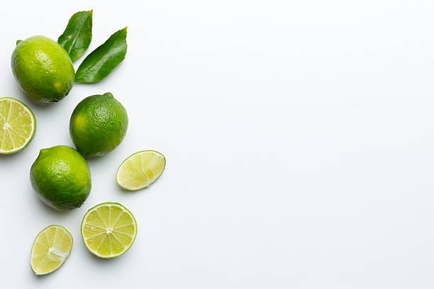 istock Lime fruits with green leaf and cut in half slice isolated on white background. Top view. Flat lay with copy space 2207729256