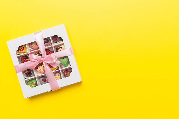istock Box with sweet chocolate candies on color background, Various candy sweets. Valentines day gift box. Top view flat lay with copy space 2207729324