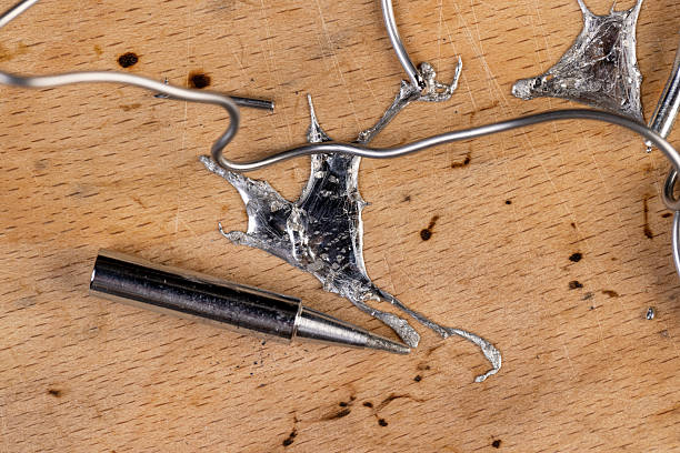 thin solder and soldering iron tips, twisted solder for repair work with soldering, closeup
