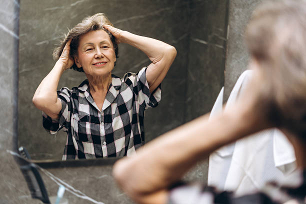 istock Elderly woman admiring herself in the mirror 2207730794