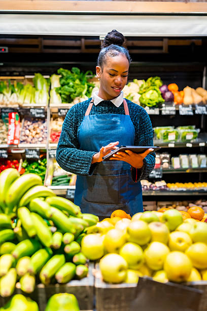 istock Saleswoman using digital tablet while working at organic supermarket 2207731623