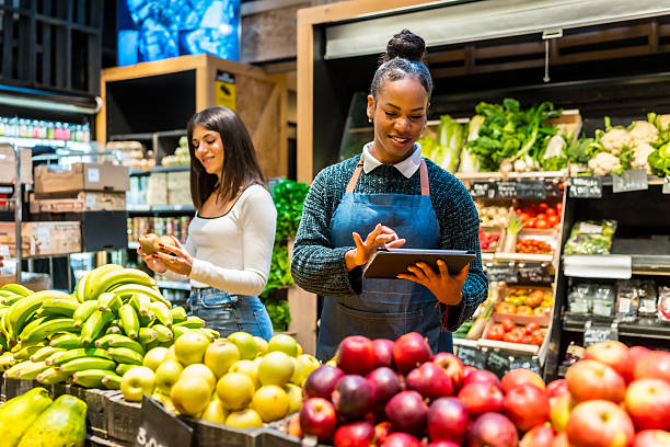 istock Saleswoman using digital tablet while working at organic supermarket 2207731673