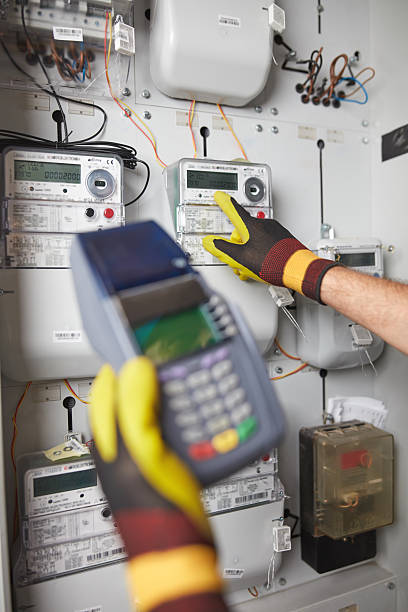 istock Technician reading consumption and charging on a wireless electricity power meter station in a building. 2207731980