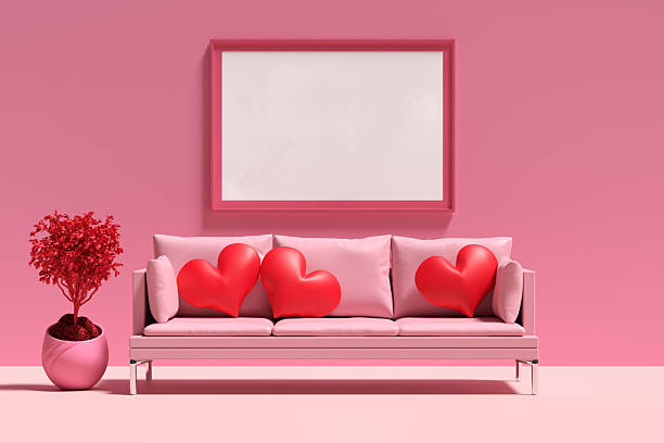 istock Pink sofa with heart-shaped cushions and a blank frame hanging on the wall 2207734188