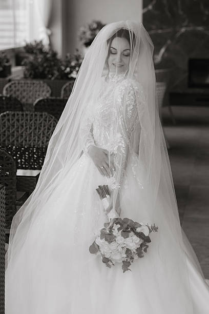 istock A bride is wearing a white dress and a veil 2207735155